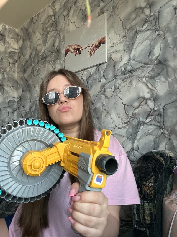 Woman poses with toy gun in playful indoor selfie session