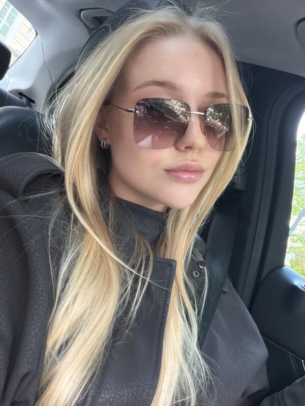 Blonde woman in sunglasses observed in car passenger seat