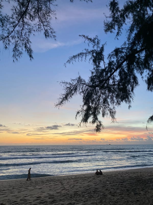 Golden hour on a Choeng Thale beach, phones in hand