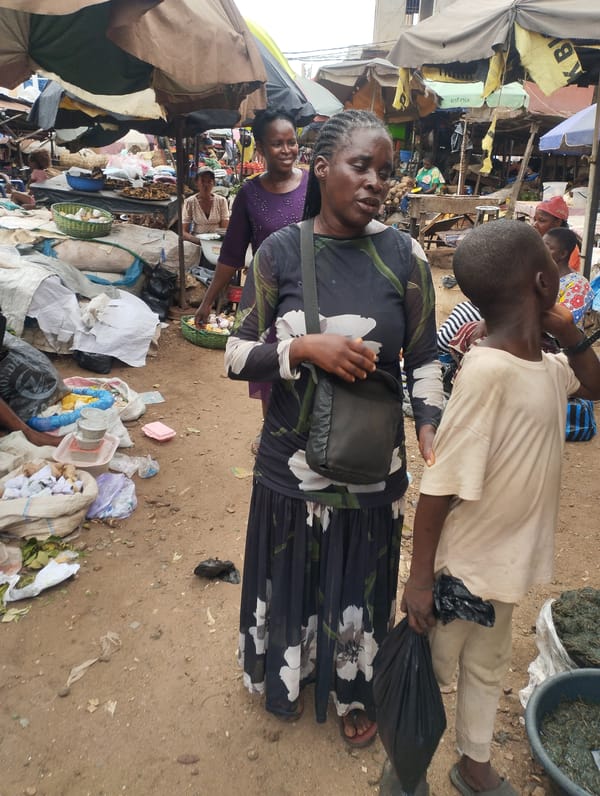 Woman converses at busy Fegge market in Nigeria