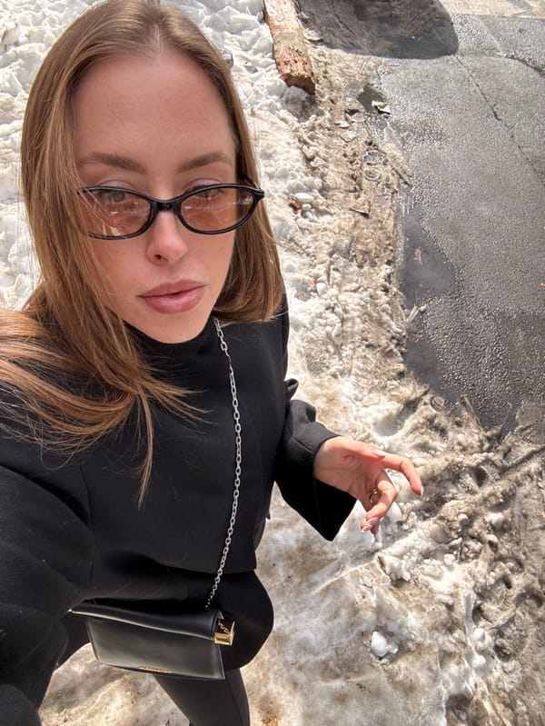 Person photographed in urban winter scene with melting snow