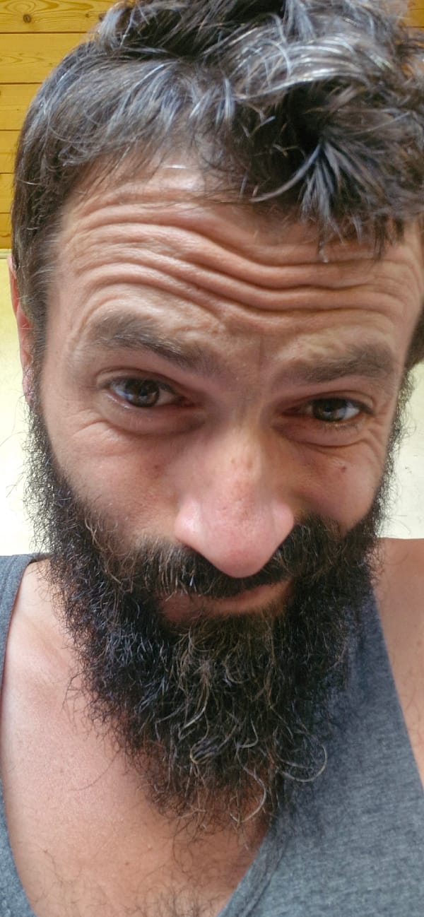 Bearded selfie series: expressive close-ups in a gray tank top