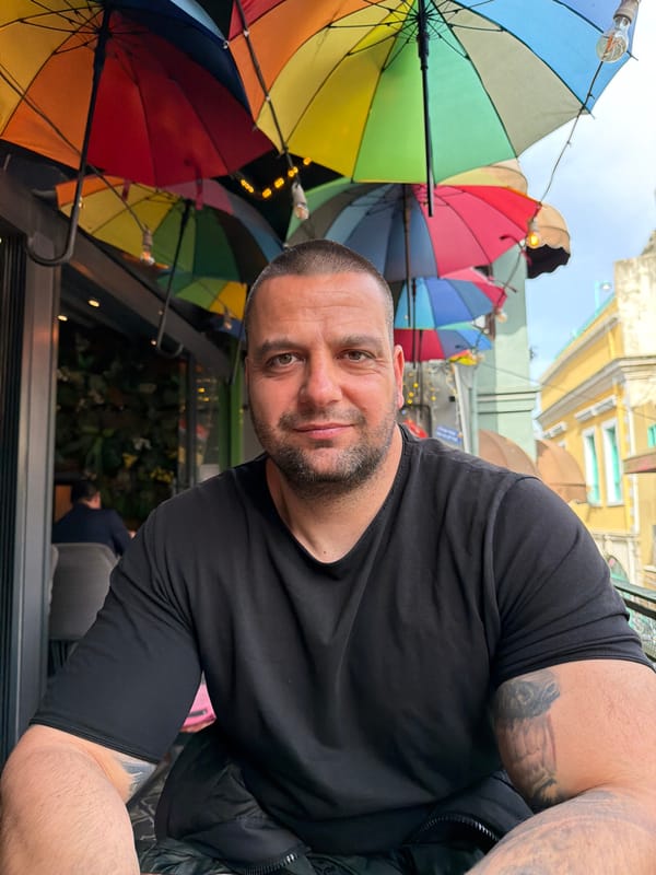 Tattooed man spotted near colorful umbrella display in Beyoğlu