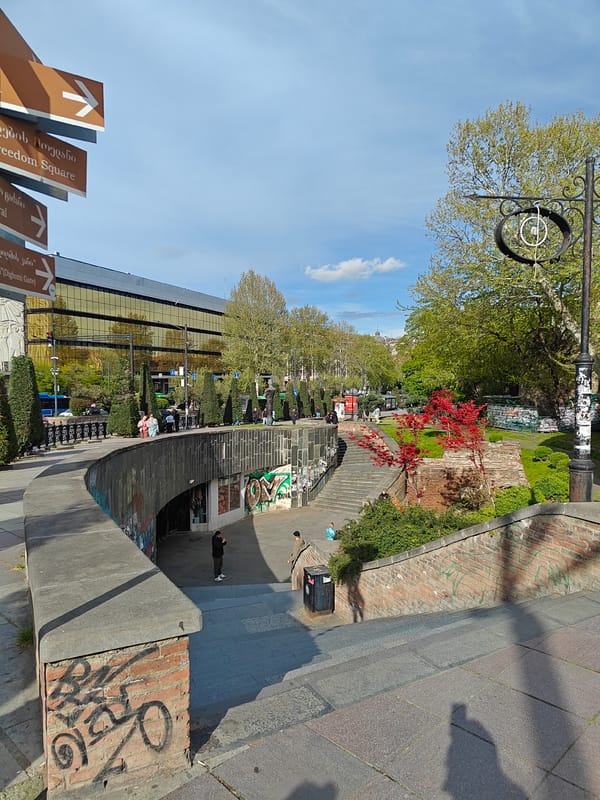 Tourist documents daytime scenes across historic Tbilisi neighborhoods