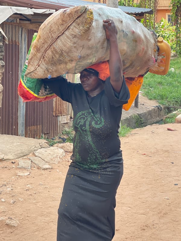 Woman carries recyclables in burlap sack in Nkpor, Nigeria