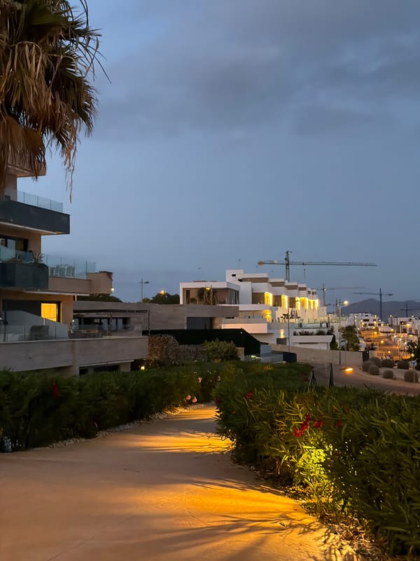 Dusk at a Finestrat resort: pools, padel, and city views