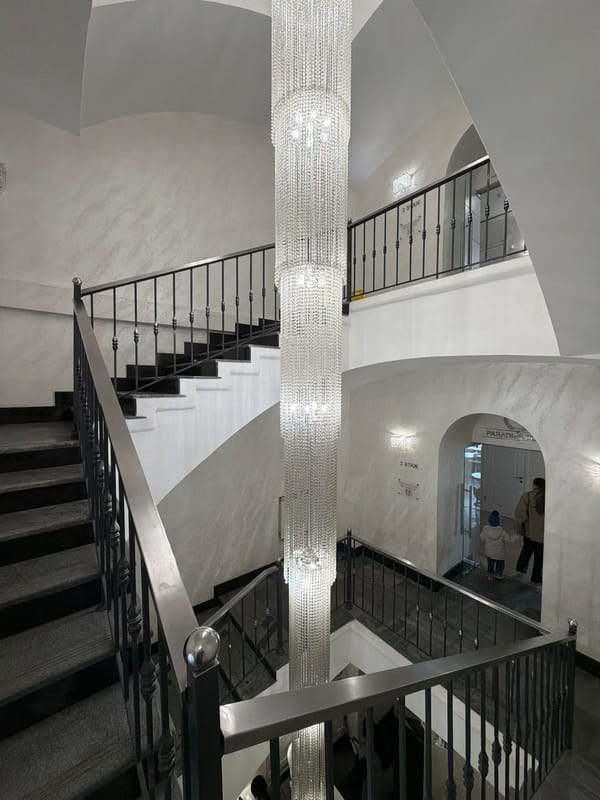 Large crystal chandelier documented in Moscow multi-story staircase interior