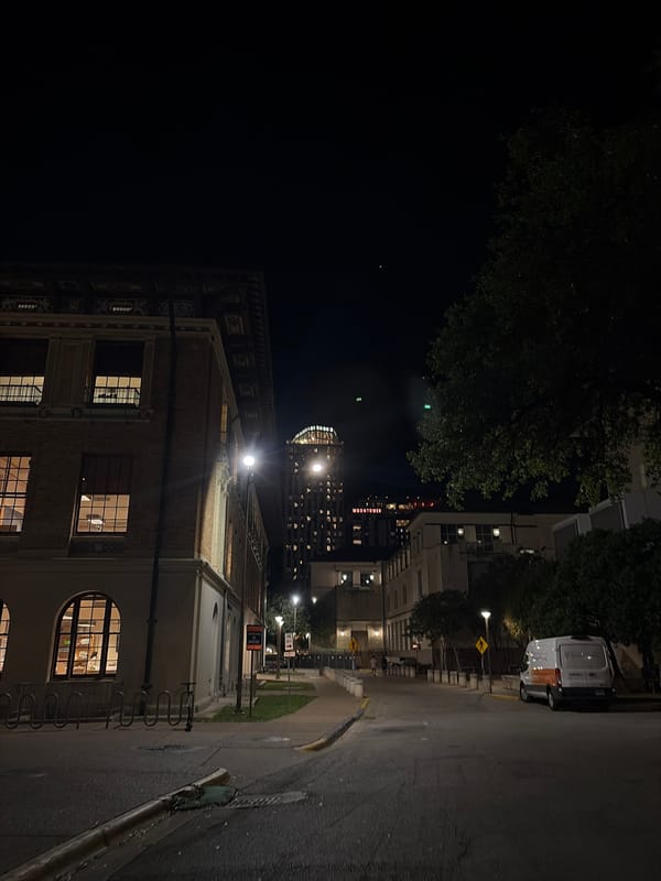Illuminated academic building photographed during Austin night
