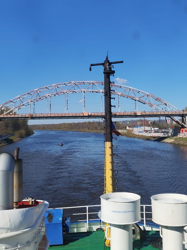 Gravel barge navigates Moscow Canal under steel bridge in Dmitrov