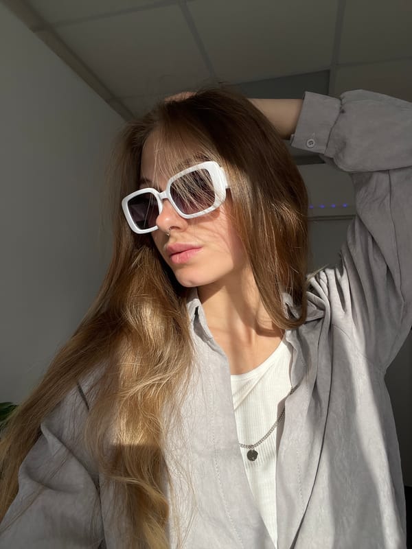 Woman takes selfies in sunlit room in Foki, Russia
