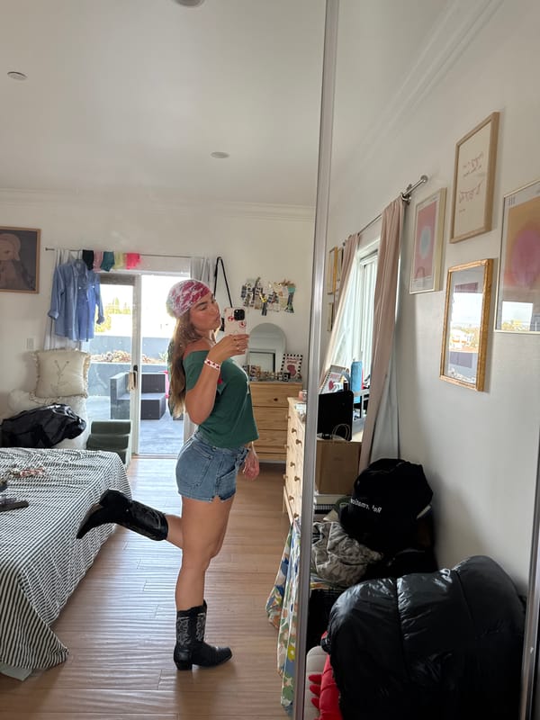 Late-night mirror selfie in LA bedroom, cowboy boots and denim