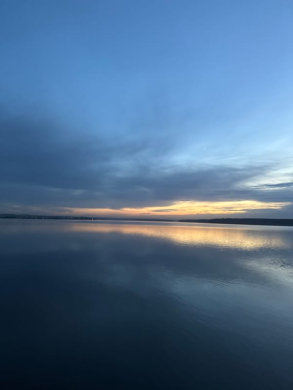 Sunset reflection captured over Votkinsk waters amid mixed clouds