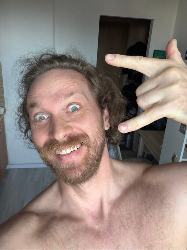 Shirtless man photographed gesturing and smiling in Saint Petersburg