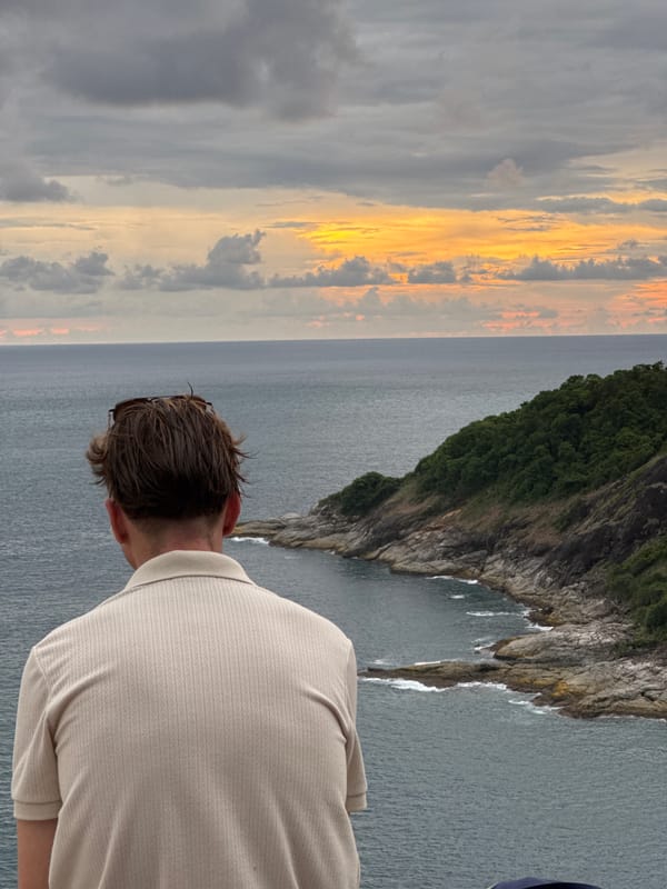 Rawai clifftop viewpoint busy with visitors, ocean views, and sailing boats