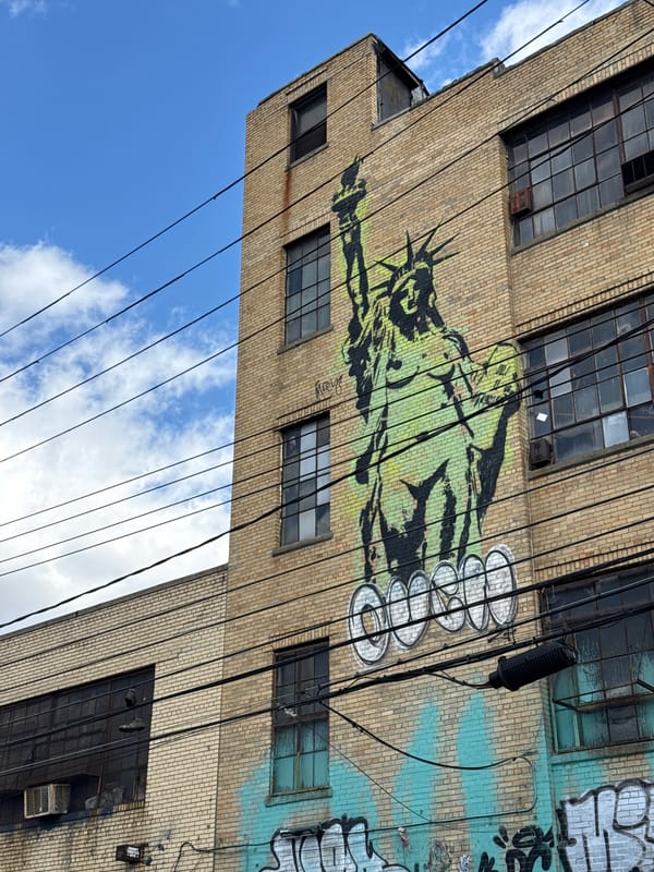 NYC brick building displays Statue of Liberty graffiti art