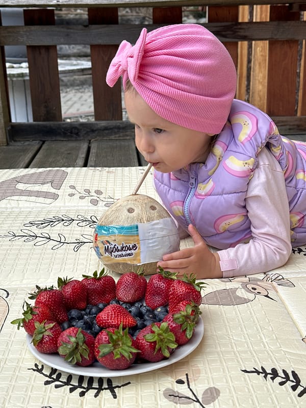 Toddler enjoys outdoor snack time on deck in Wisła