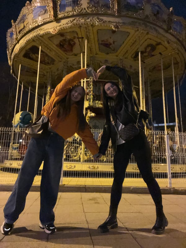 Two women explore illuminated Tyumen attractions during evening outing