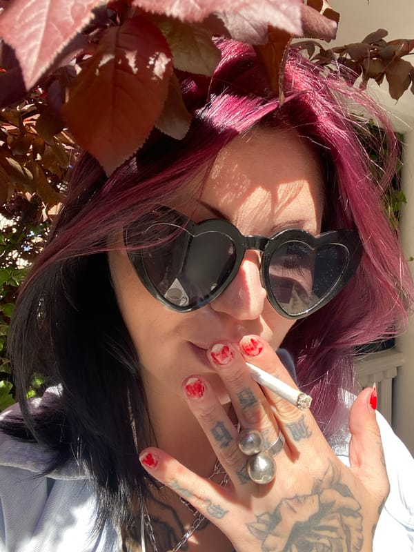 Person with magenta hair enjoys coffee outdoors in Montenegro