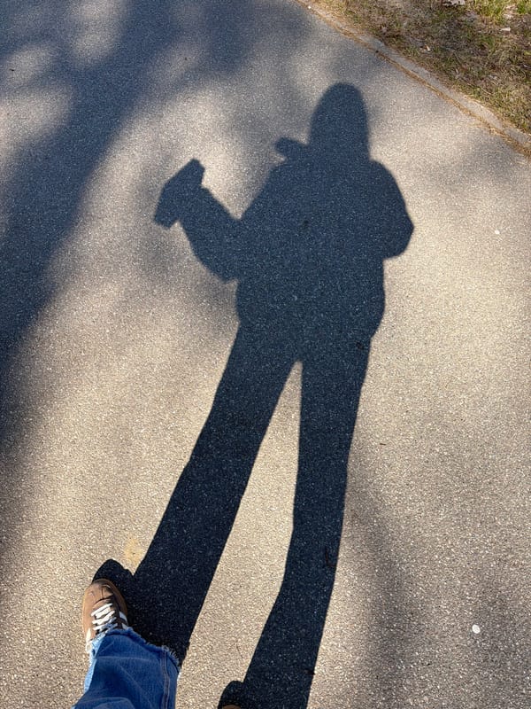 Person photographing creates shadow on Riga sidewalk
