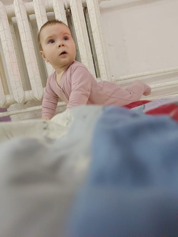 Baby crawls on bed in Russian home