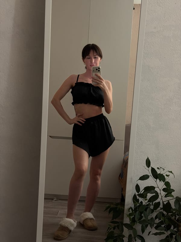 Woman takes mirror selfies in black outfit, Perm apartment
