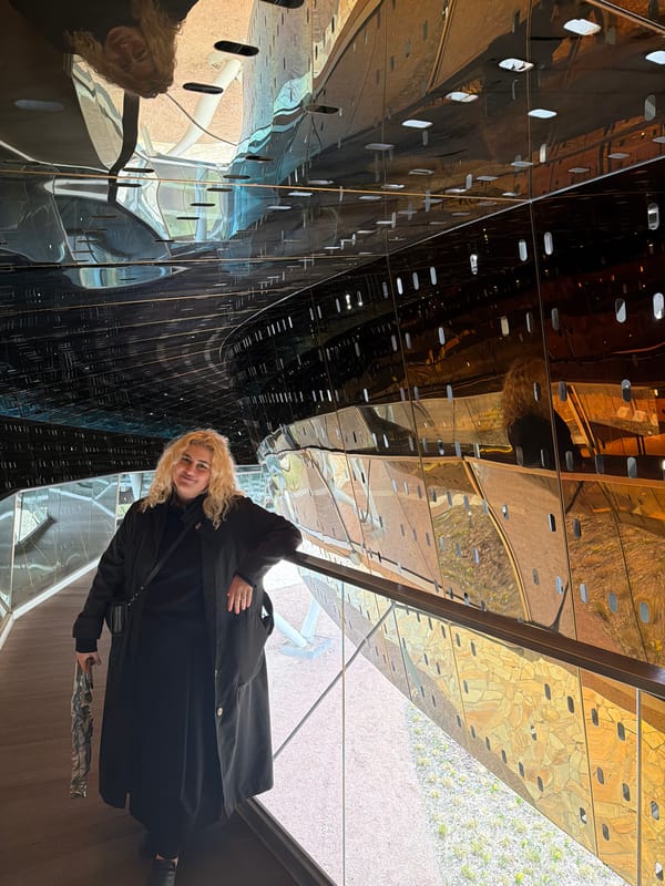 Woman in black observed in reflective space in Moscow