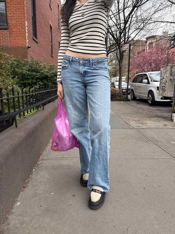 Person walks NYC residential sidewalk in striped shirt