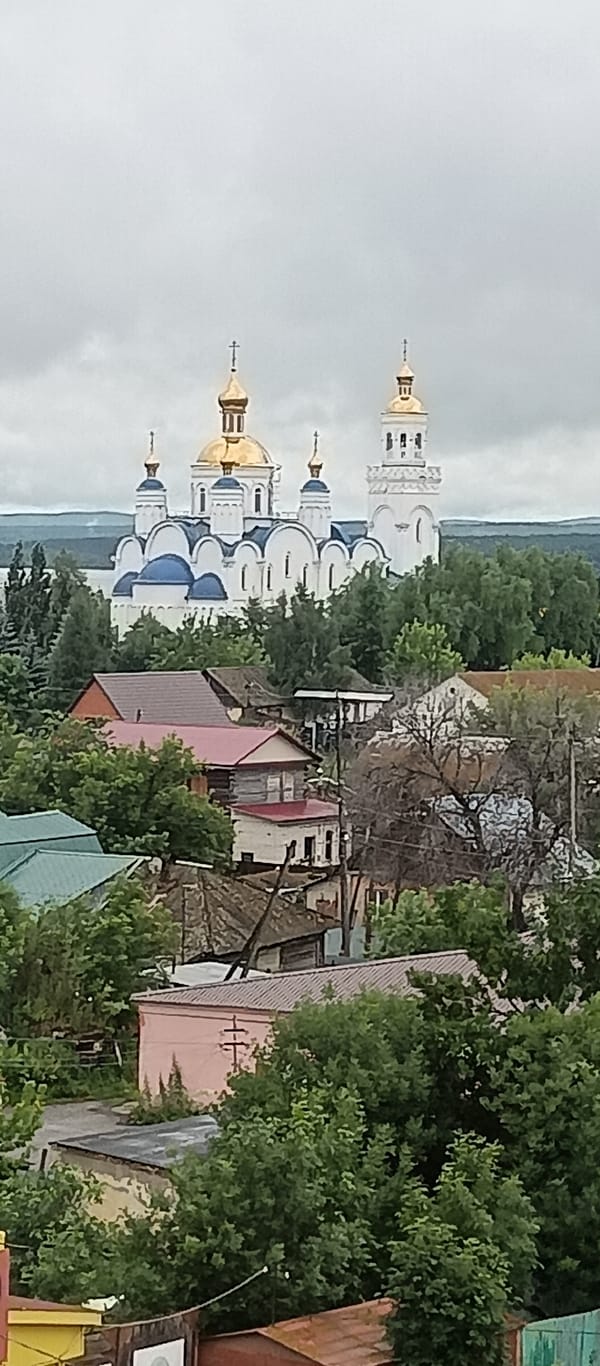 Orthodox church with golden domes stands over Chebarkul skyline
