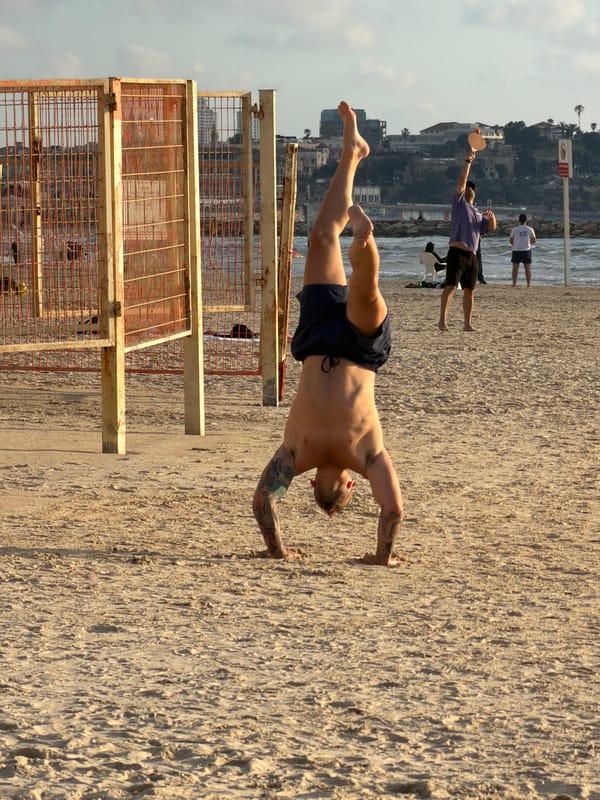 Helicopter flies over Tel Aviv beach during afternoon Matkot games