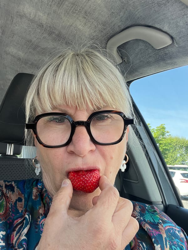 Woman poses with strawberry in playful car selfies