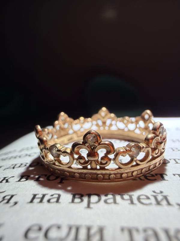 Gold crown and ring photographed on Russian text pages