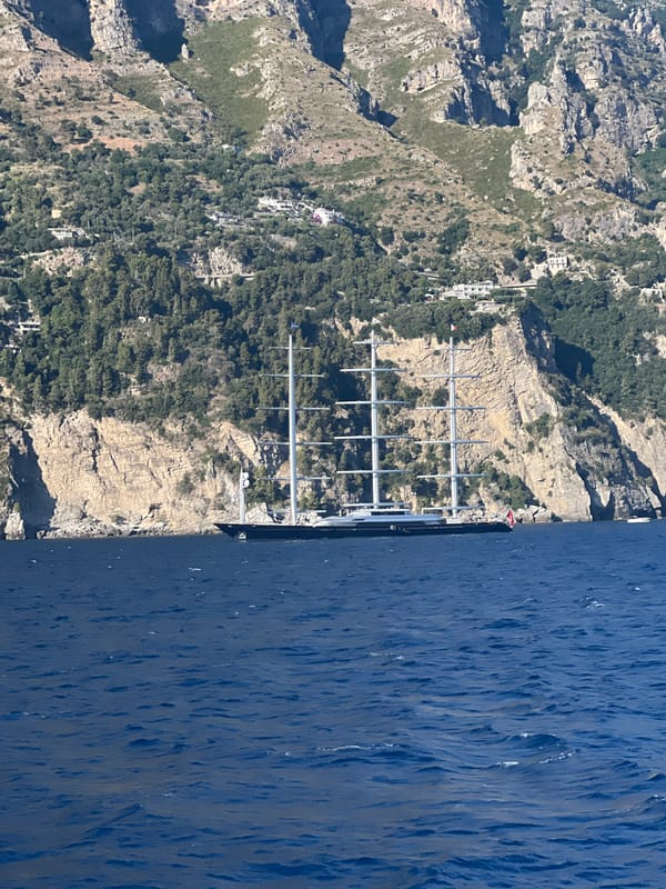Boat journey captures Amalfi Coast views, anchored yacht