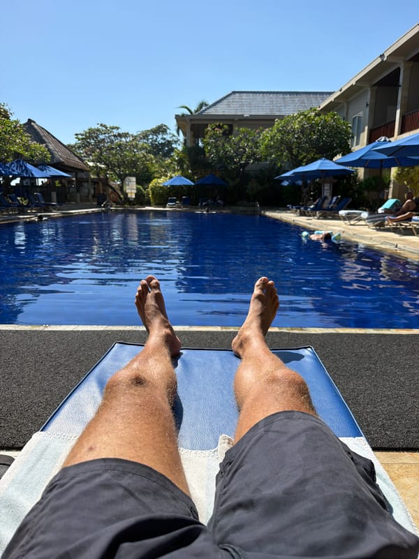 Poolside relaxation at a Buleleng resort, legs up.