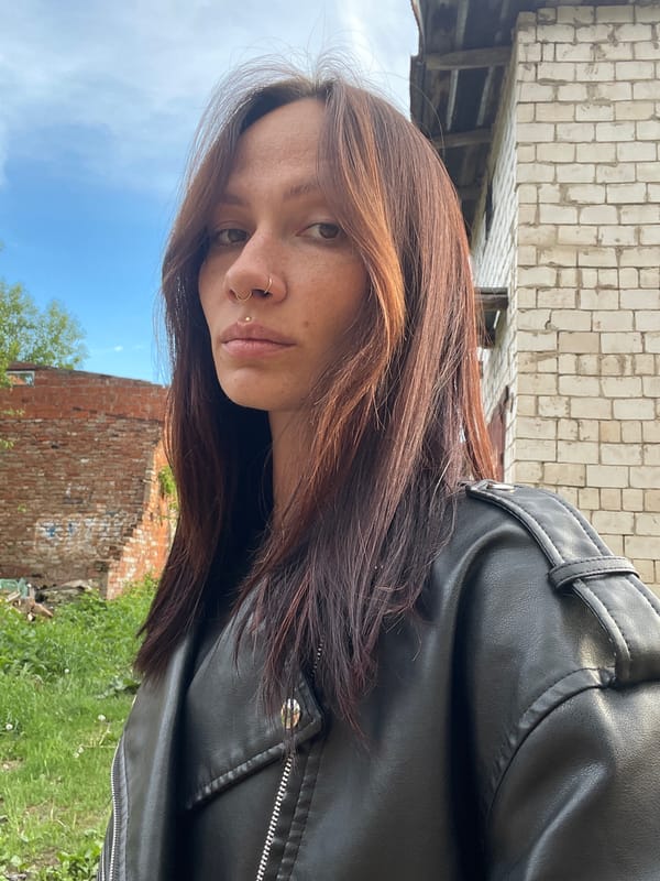 Woman photographs herself near brick garages in rural Russia