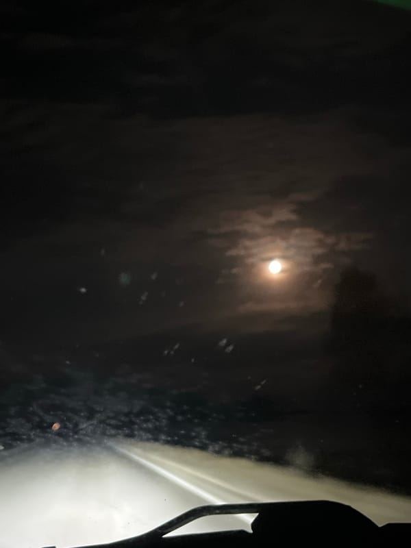 Moon partially obscured by clouds observed through window in Russia