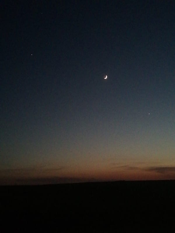 Night sky observation shows crescent moon, celestial objects