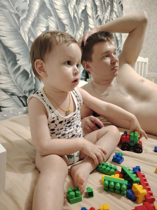 Domestic moment captured between toddler and adult male indoors