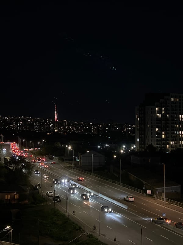 Red tower illuminated in nighttime Yerevan cityscape