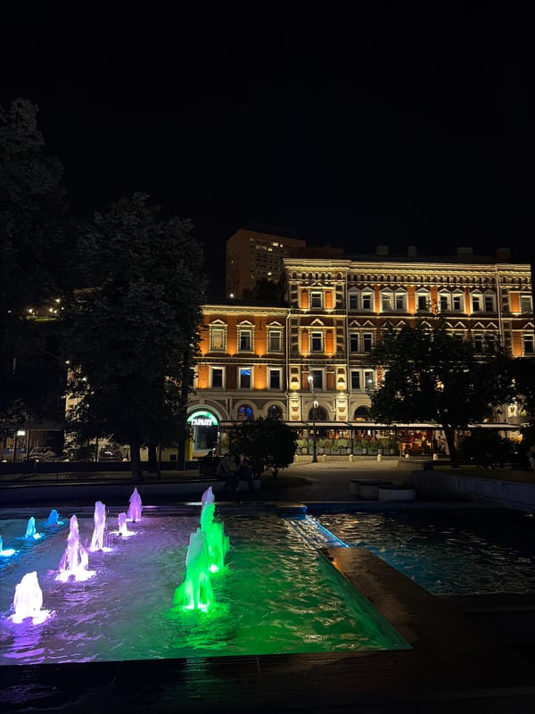 City landmarks at night: fountain, statue, and domed church
