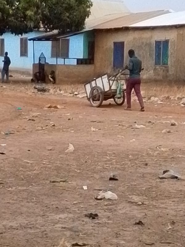 Children play while man pulls cart in urban area
