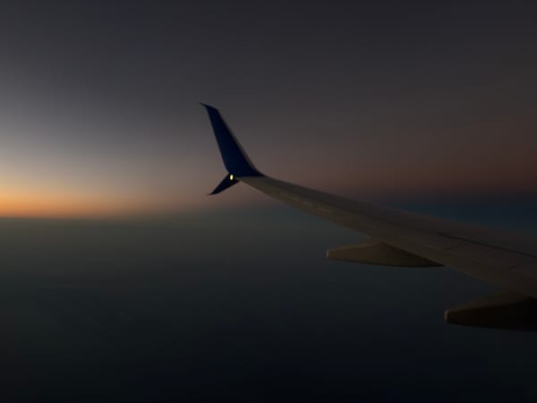 Airplane wing photographed against twilight sky near Port Fourchon
