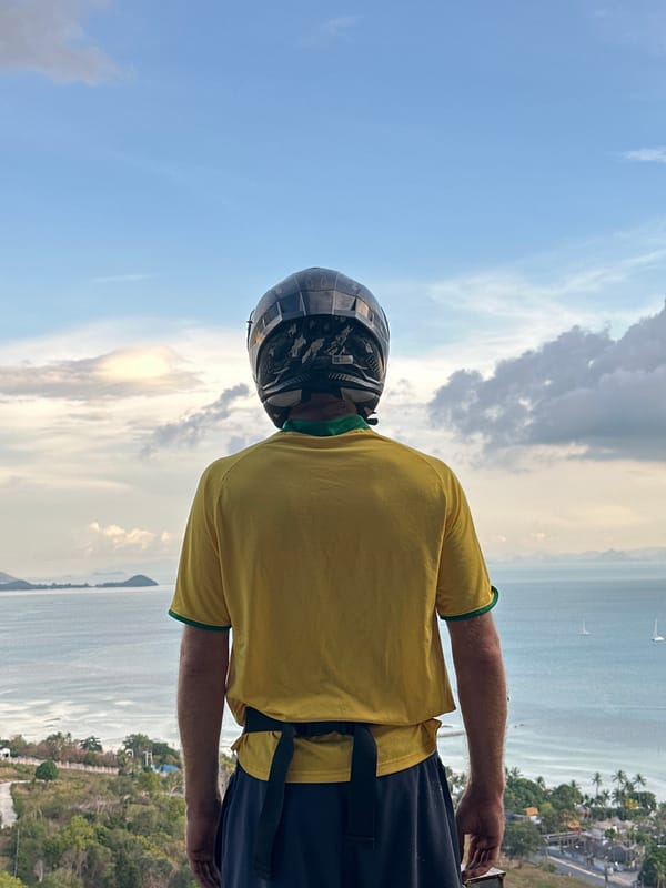 Motorcyclist pauses for ocean view in Nathon, Thailand