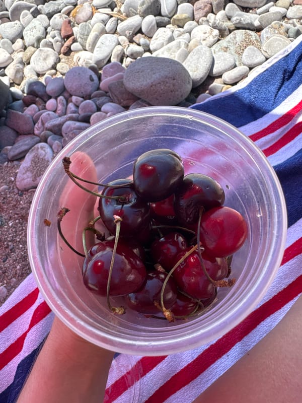 Lazy beach afternoon in Šušanj, Montenegro — cherries, pebbles, sunshine.
