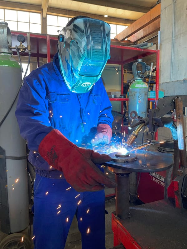 Welder at work in a Montenegrin workshop, sparks flying