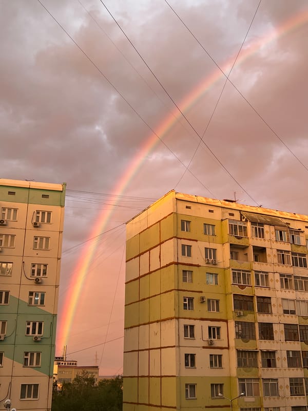 Rainbow and sunset light over Yakutsk apartment blocks
