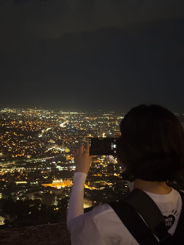 Nighttime views over Tbilisi from a lit classical balcony