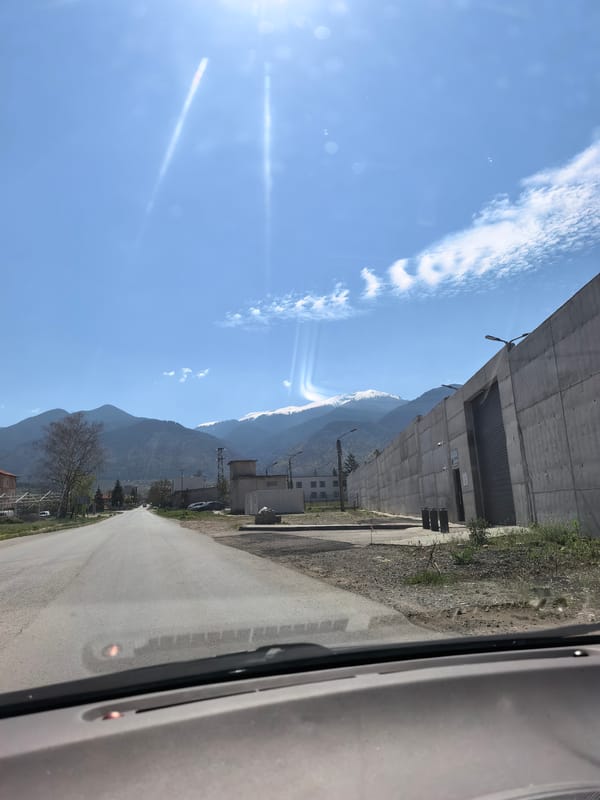 Driver documents sunny mountain road journey through rural countryside