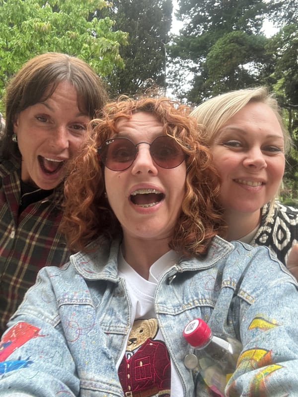 Women take selfie near resting person in Sochi park