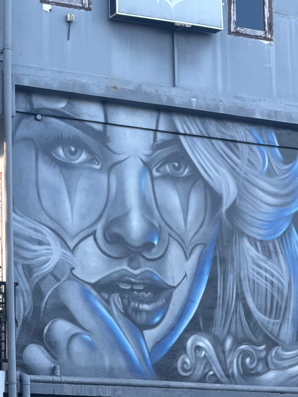 Blue and white face mural spotted on Kuta building