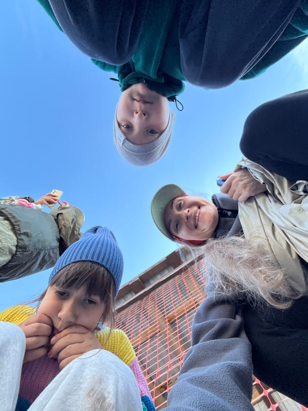 Looking up at faces against a blue Arctic sky in Teriberka